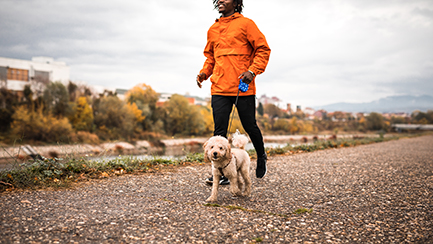 Man and dog running together near the river
